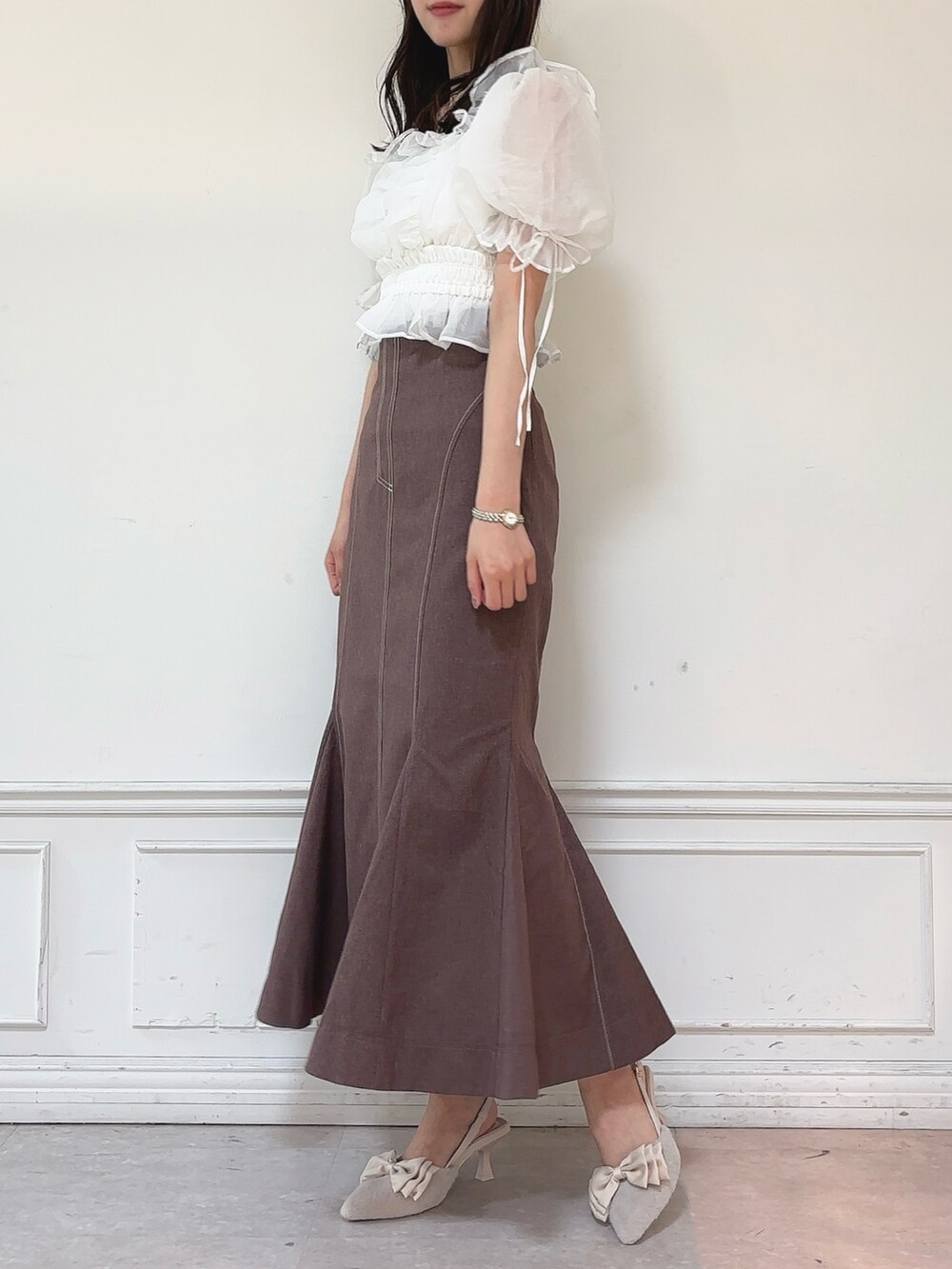 ブラウン系のスカート、ホワイト系のシャツ/ブラウス、ベージュ系のパンプスを着用したレディースの秋コーディネートの3枚目の写真