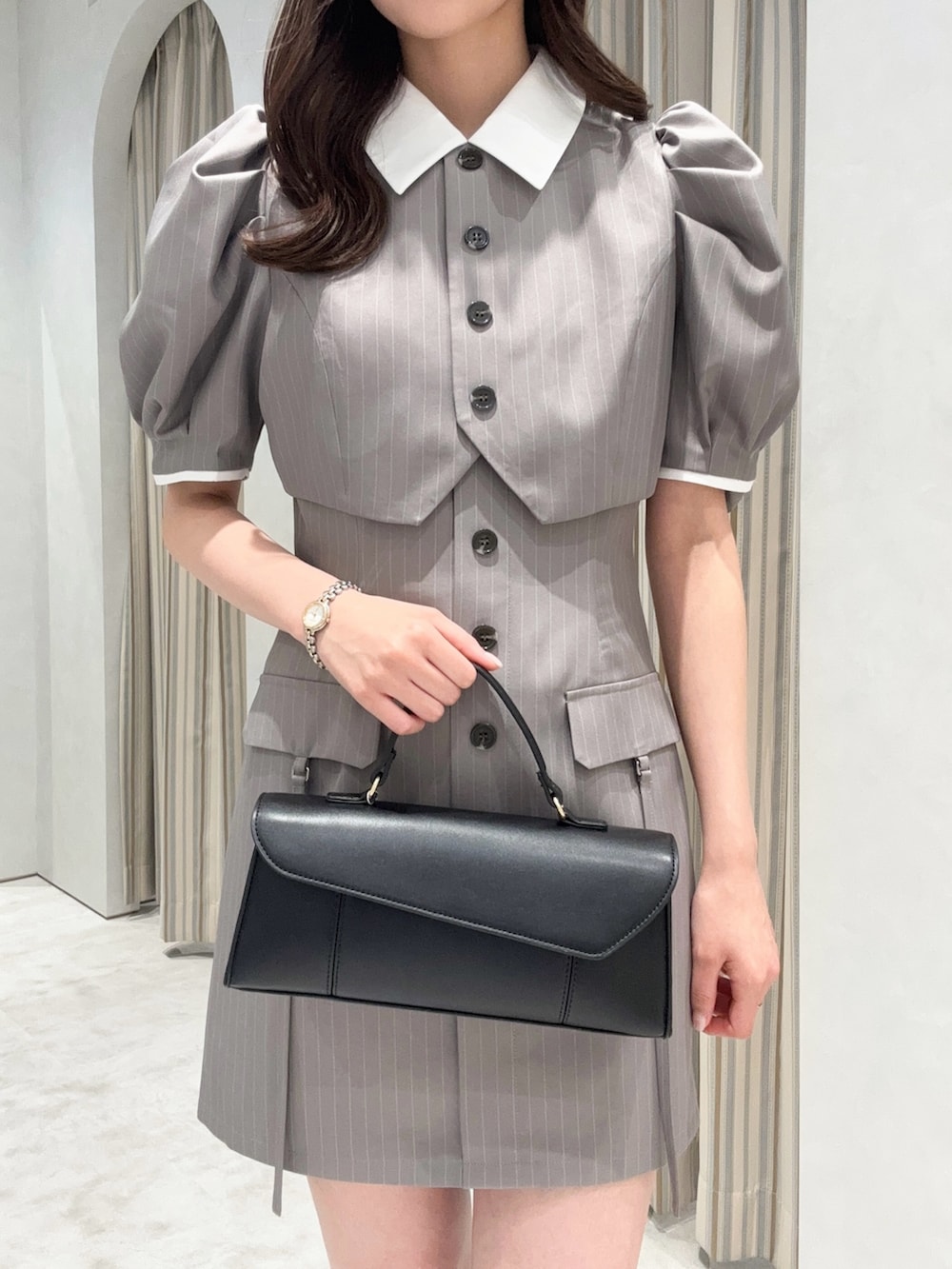 グレー系のワンピース、ブラック系のローファーを着用したレディースの春コーディネートの5枚目の写真