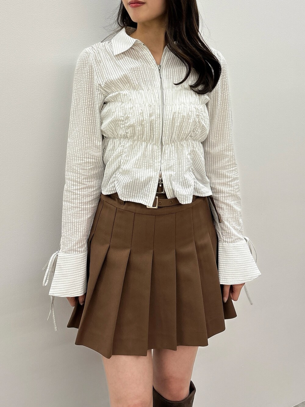 ブルー系のシャツ/ブラウス、イエロー系のスカート、ブラウン系のブーツを着用したレディースの春コーディネートの5枚目の写真