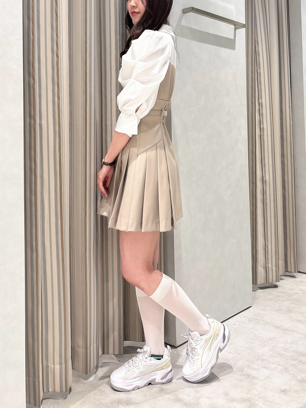 ベージュ系のワンピース、ホワイト系のスニーカーを着用したレディースの春コーディネートの3枚目の写真