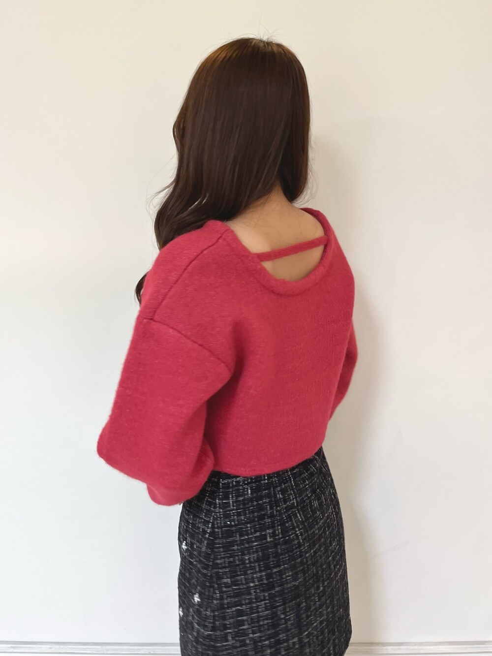 ブラック系のブーツ、ブラック系のスカート、レッド系のニット/セーターを着用したレディースの秋コーディネートの4枚目の写真