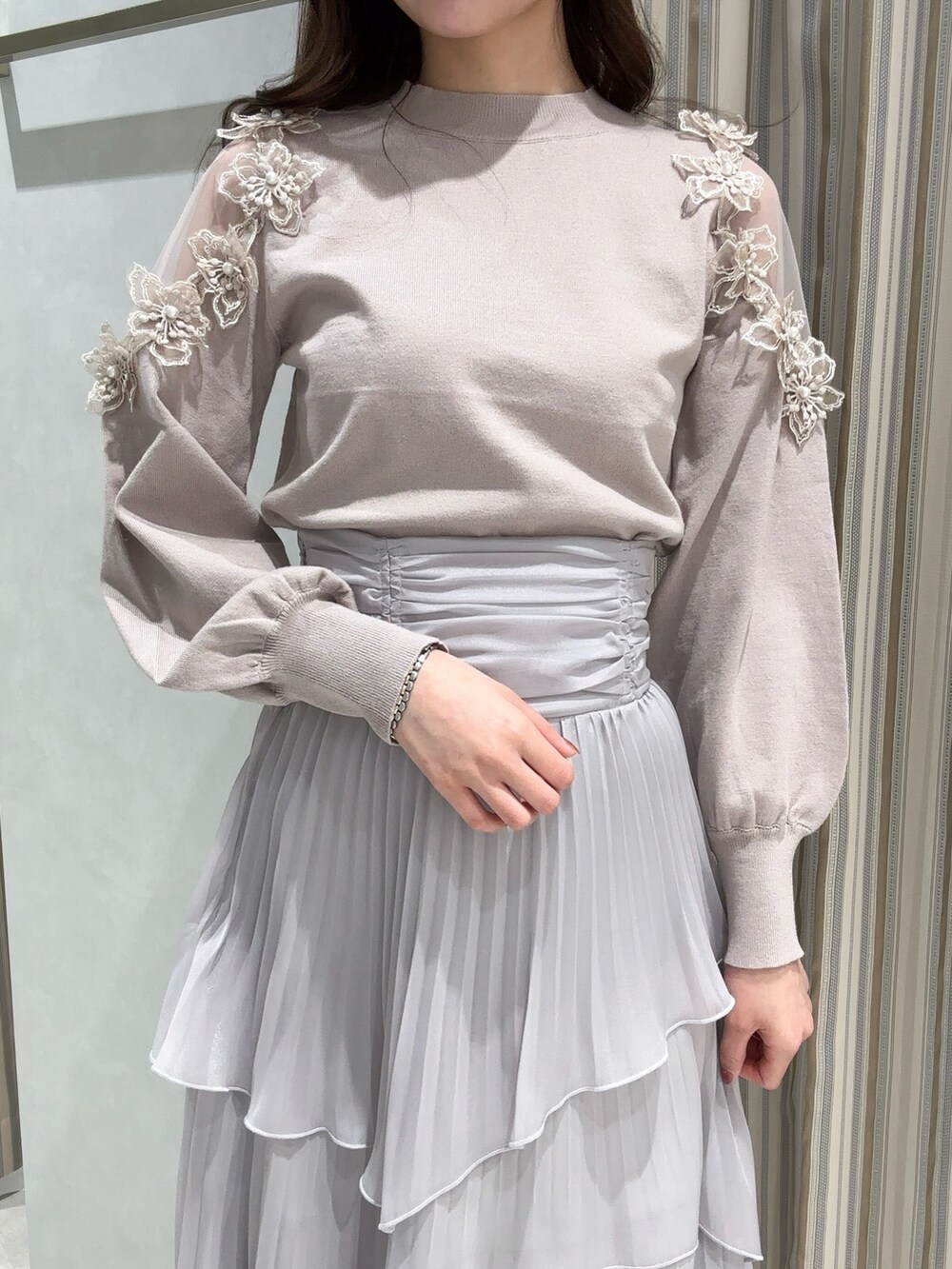 ピンク系のニット/セーター、グレー系のスカート、ベージュ系のパンプスを着用したレディースの冬コーディネートの5枚目の写真