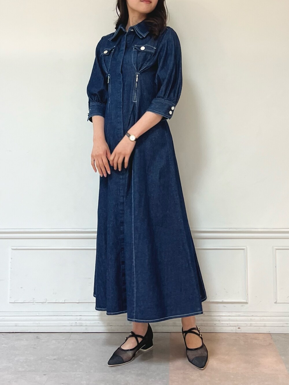 ブルー系のワンピース、ブラック系のパンプスを着用したレディースの冬コーディネートの3枚目の写真