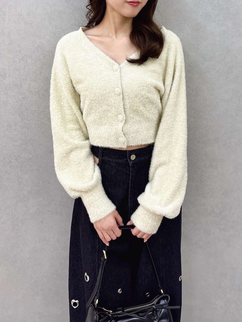 ベージュ系のカーディガン/ボレロ、ブルー系のデニムパンツ、ブラック系のパンプスを着用したレディースの冬コーディネートの6枚目の写真