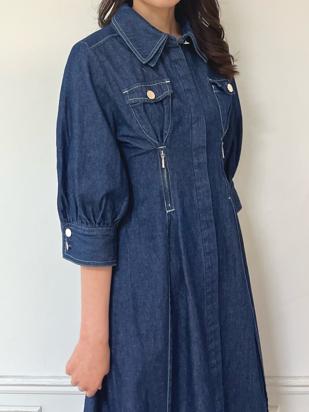 ブルー系のワンピース、ブラック系のパンプスを着用したレディースの冬コーディネートの7枚目の写真