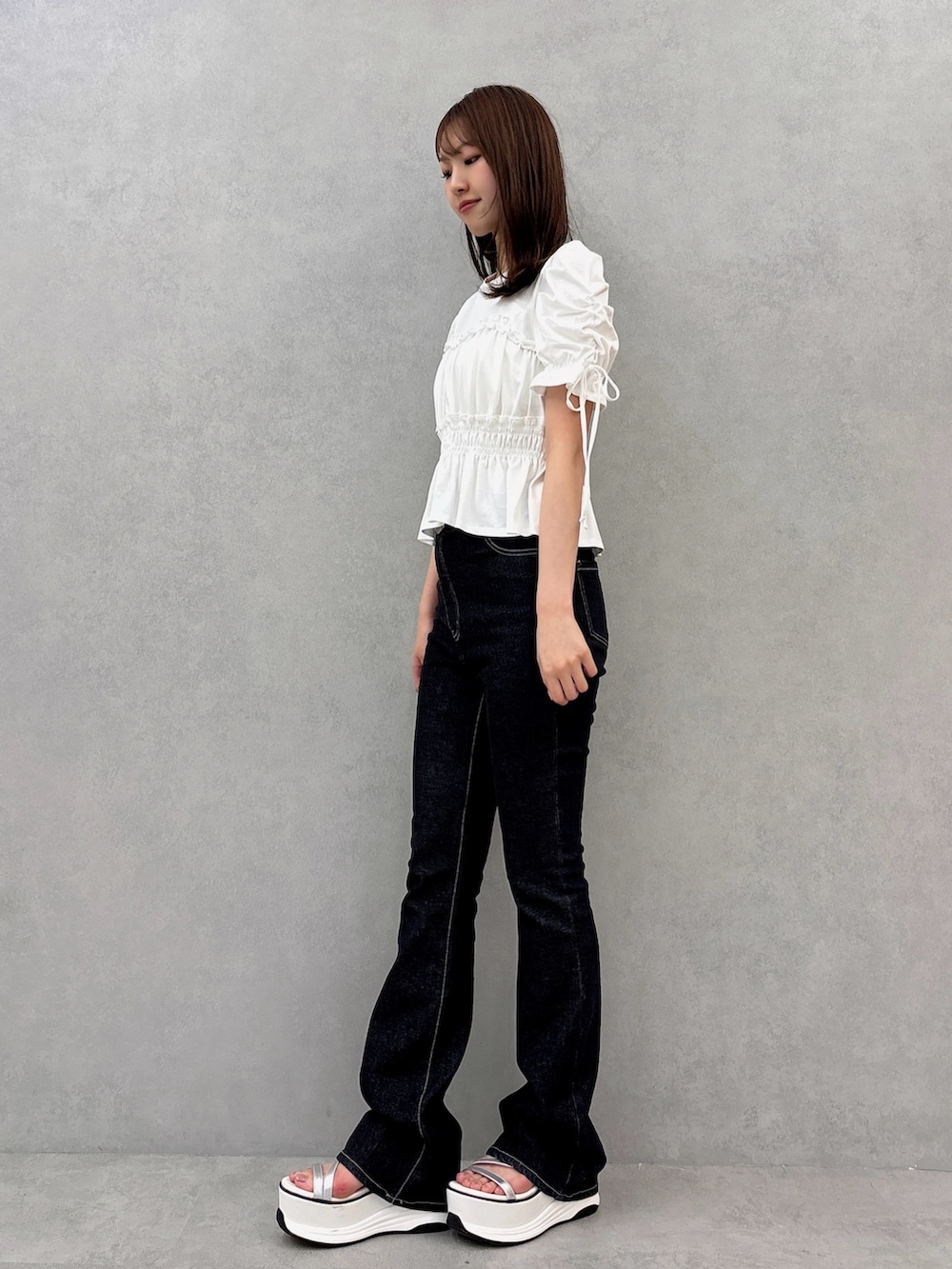 ホワイト系のTシャツ/カットソー、ブラック系のデニムパンツ、ホワイト系のサンダルを着用したレディースの夏コーディネートの3枚目の写真