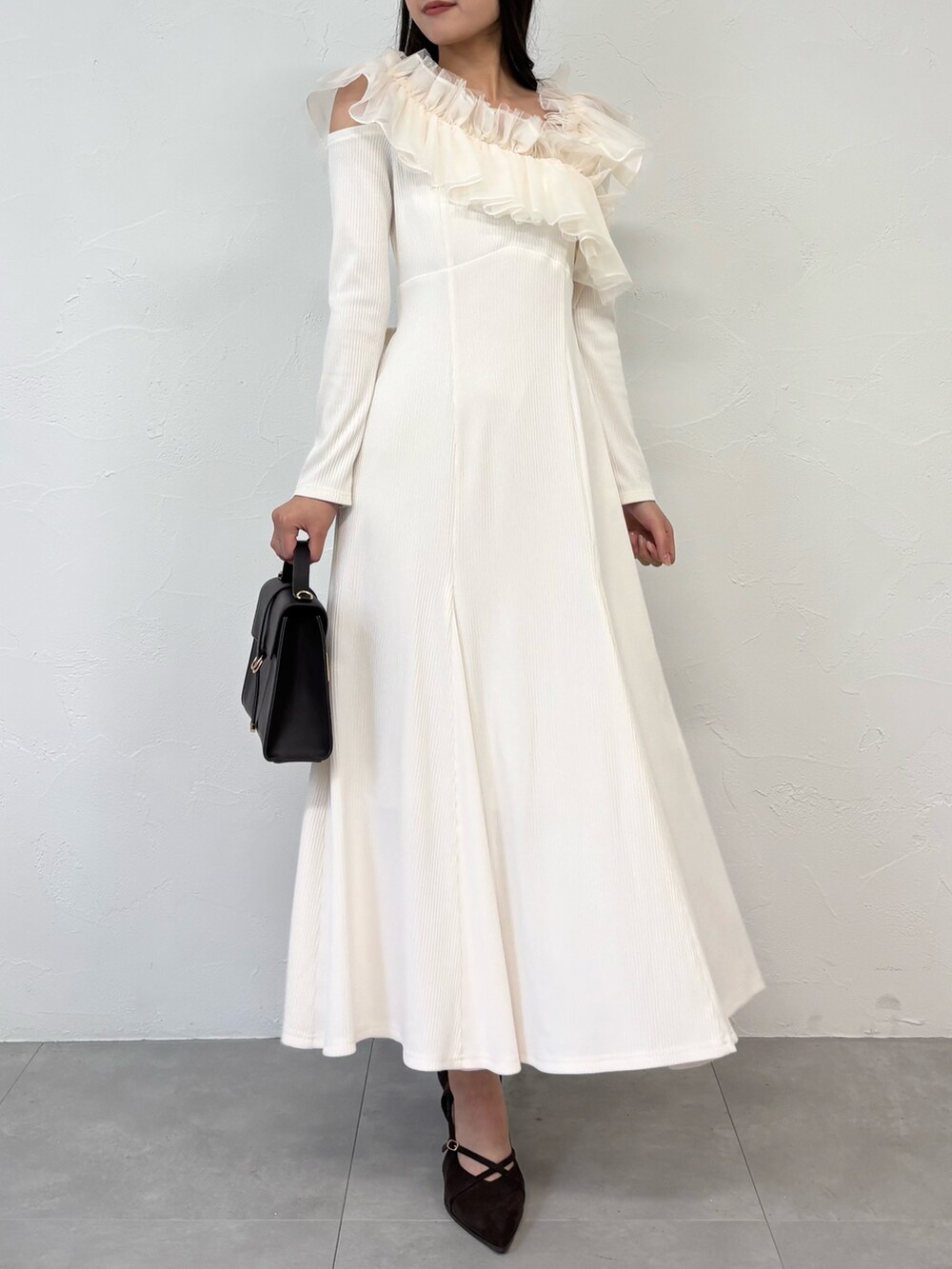 ブラウン系のショルダーバッグ、ブラウン系のパンプス、ホワイト系のワンピースを着用したレディースの秋コーディネートの3枚目の写真