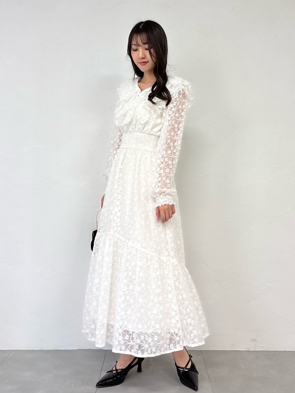 ホワイト系のワンピース、ブラック系のパンプスを着用したレディースの秋コーディネートの5枚目の写真