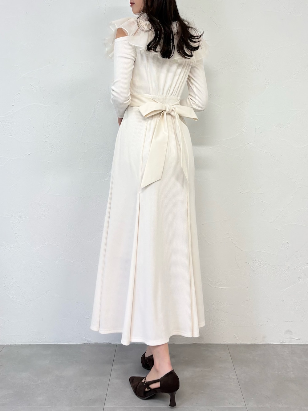 ブラウン系のショルダーバッグ、ブラウン系のパンプス、ホワイト系のワンピースを着用したレディースの秋コーディネートの6枚目の写真