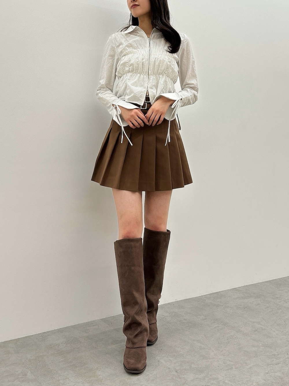 ブルー系のシャツ/ブラウス、イエロー系のスカート、ブラウン系のブーツを着用したレディースの春コーディネートの2枚目の写真