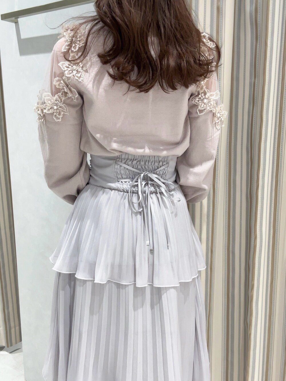 ピンク系のニット/セーター、グレー系のスカート、ベージュ系のパンプスを着用したレディースの冬コーディネートの7枚目の写真