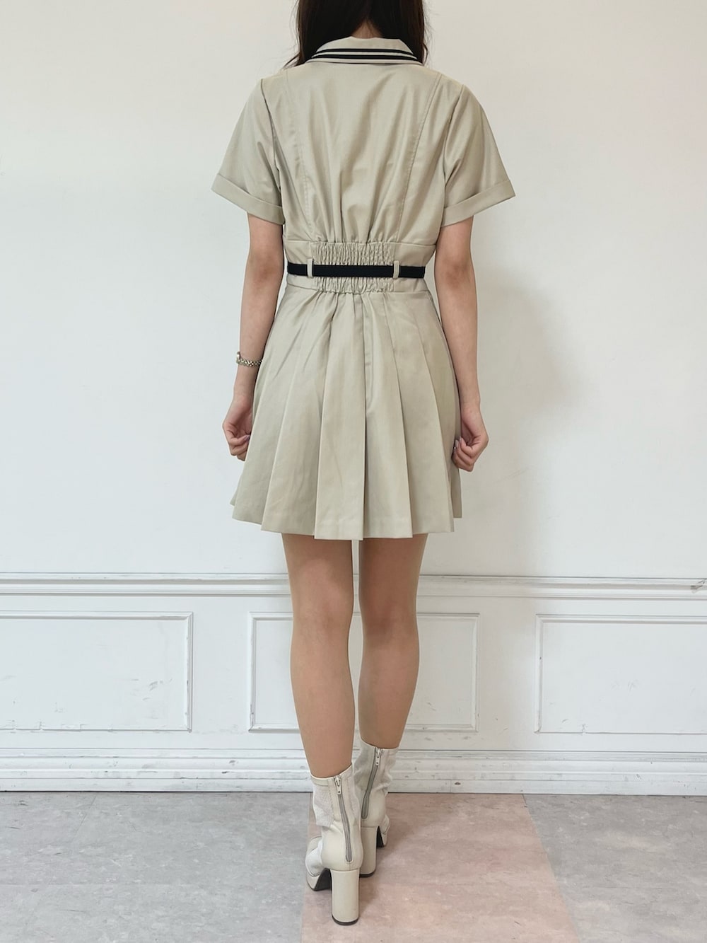 ホワイト系のブーツ、ベージュ系のワンピースを着用したレディースの春コーディネートの3枚目の写真