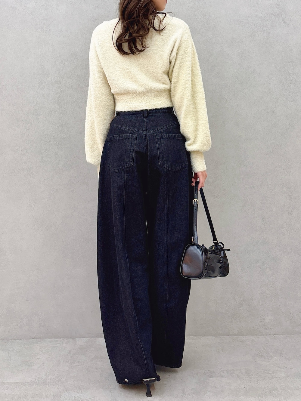 ベージュ系のカーディガン/ボレロ、ブルー系のデニムパンツ、ブラック系のパンプスを着用したレディースの冬コーディネートの5枚目の写真