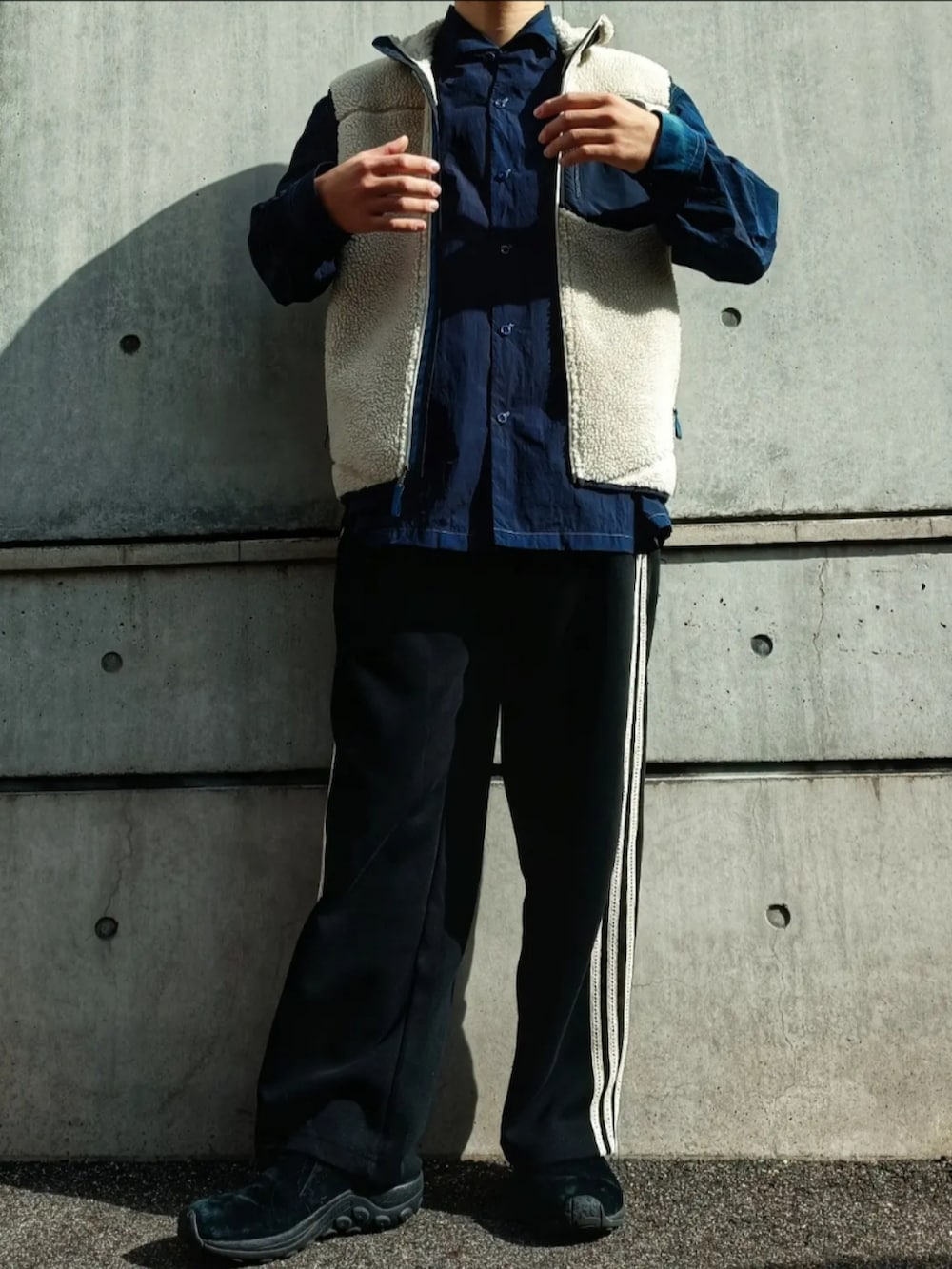 ブルー系のシャツ/ブラウス、ホワイト系のベスト、ブラック系のパンツを着用したメンズの秋コーディネートの2枚目の写真