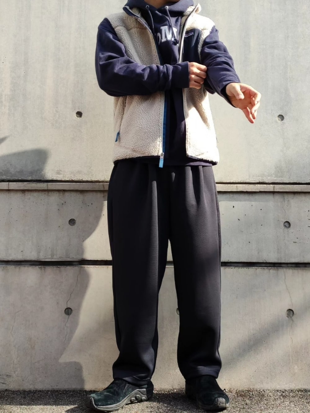 ブルー系のパーカー、ブラック系のスウェットパンツ、ブラック系のスリッポンを着用したメンズの冬コーディネートの4枚目の写真