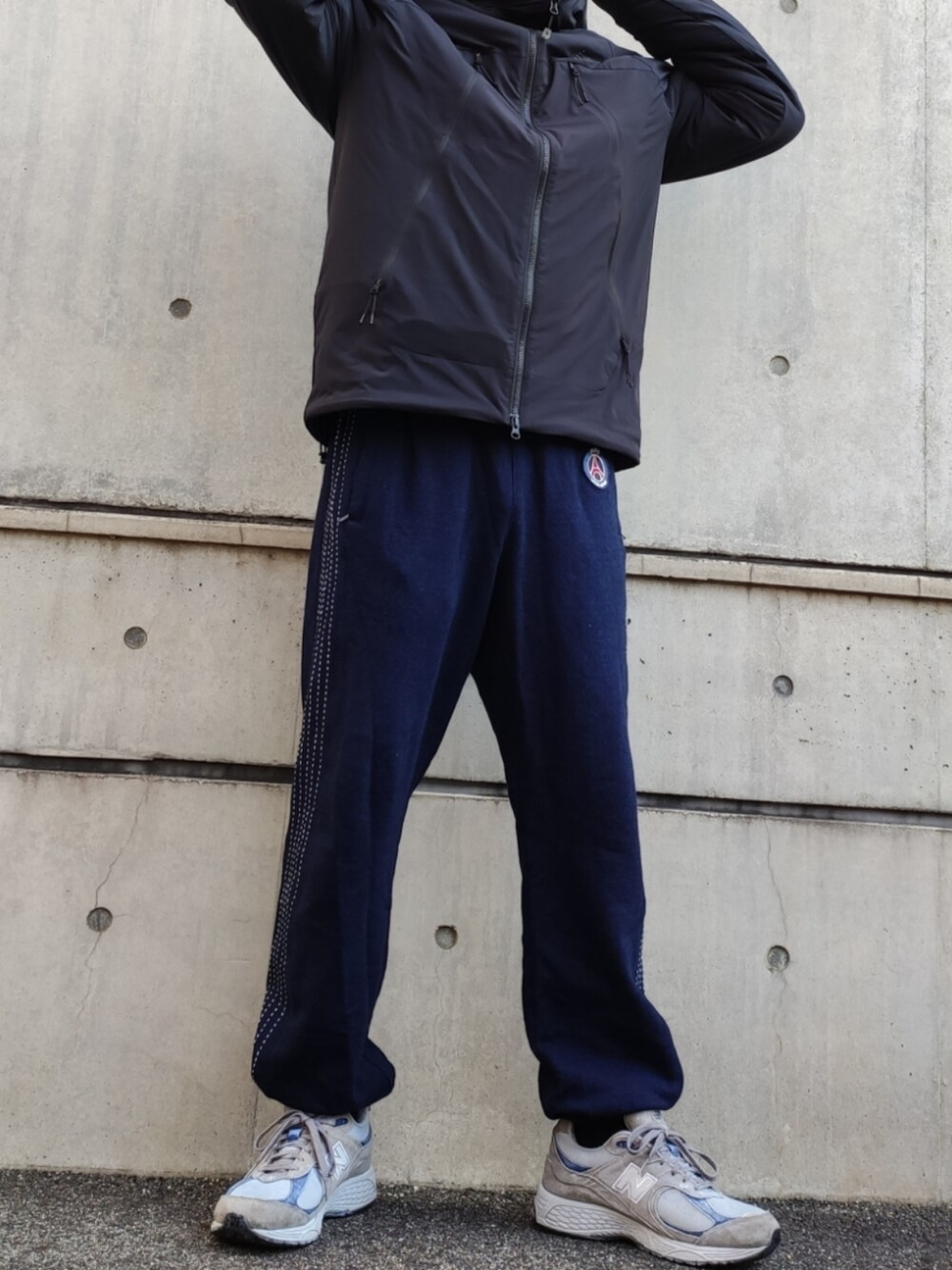 ブラック系のマウンテンパーカー、ブルー系のスウェットパンツ、グレー系のスニーカーを着用したメンズの冬コーディネートの4枚目の写真