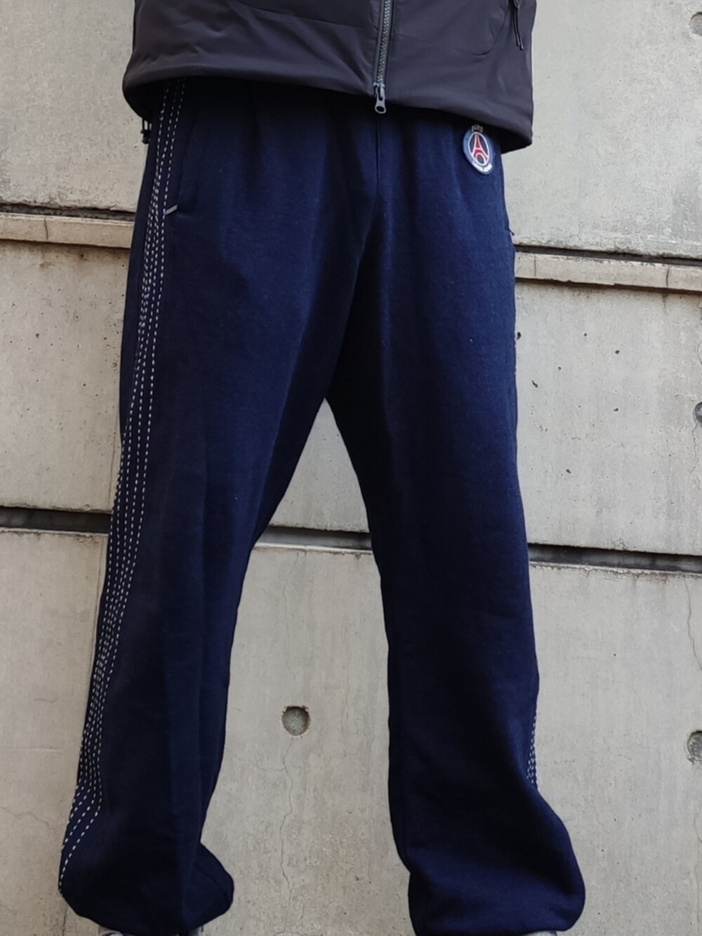 ブラック系のマウンテンパーカー、ブルー系のスウェットパンツ、グレー系のスニーカーを着用したメンズの冬コーディネートの5枚目の写真