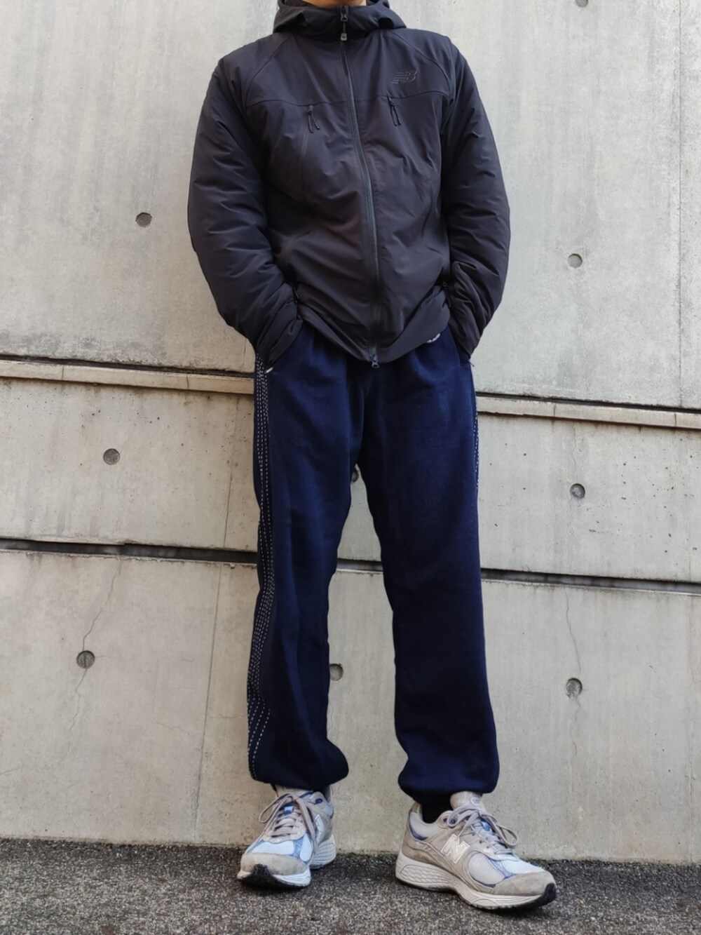 ブラック系のマウンテンパーカー、ブルー系のスウェットパンツ、グレー系のスニーカーを着用したメンズの冬コーディネートの3枚目の写真