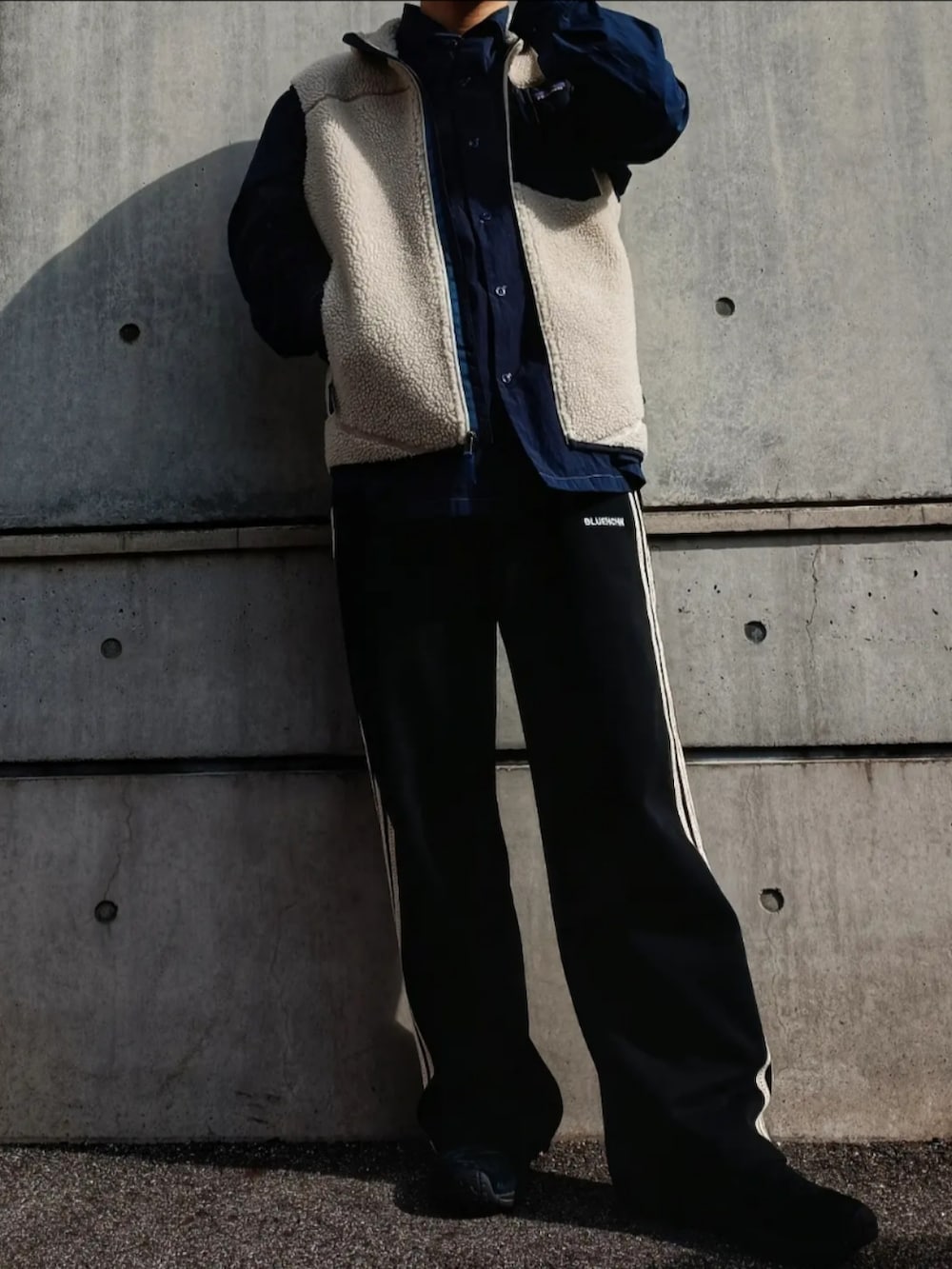 ブルー系のシャツ/ブラウス、ホワイト系のベスト、ブラック系のパンツを着用したメンズの秋コーディネートの3枚目の写真