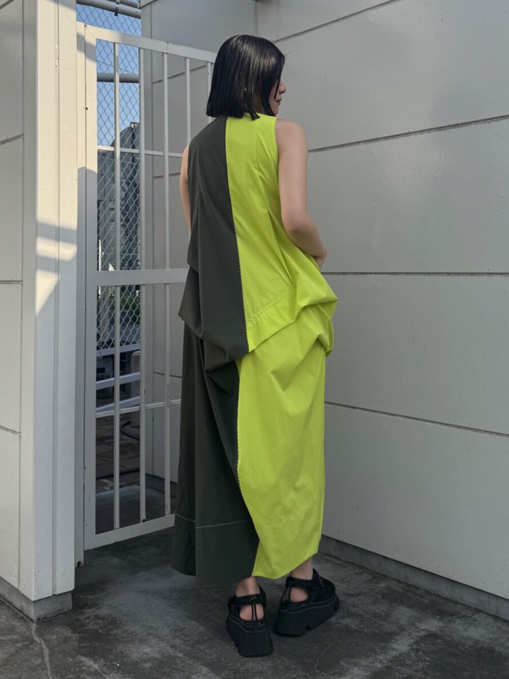 グリーン系のワンピース、ブラック系のサンダルを着用したレディースの夏コーディネートの2枚目の写真