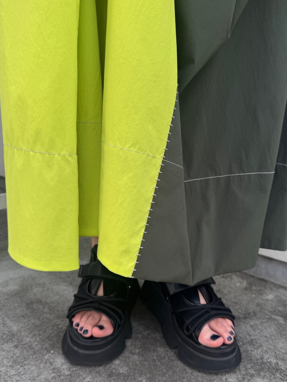 グリーン系のワンピース、ブラック系のサンダルを着用したレディースの夏コーディネートの6枚目の写真