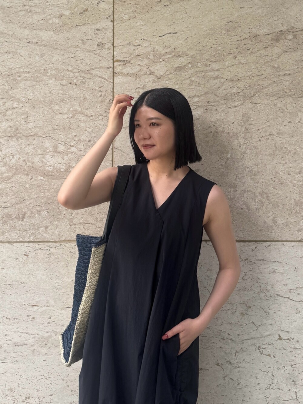 ブラック系のサンダル、ブラック系のワンピース、ブルー系のトートバッグを着用したレディースの夏コーディネートの4枚目の写真