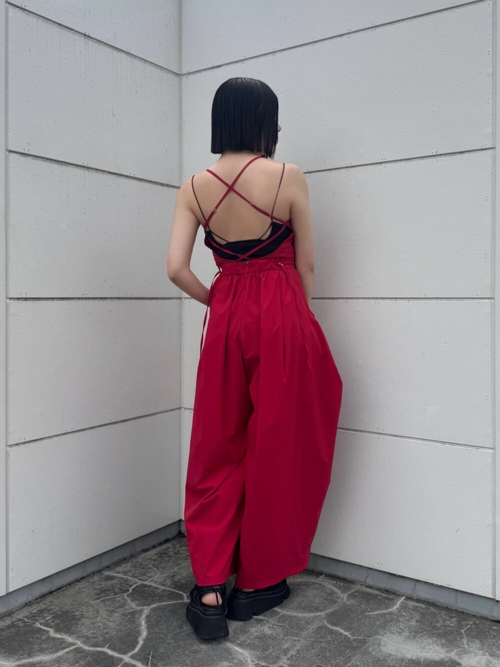 ブラック系のサンダル、レッド系のつなぎ/オールインワンを着用したレディースの夏コーディネートの2枚目の写真