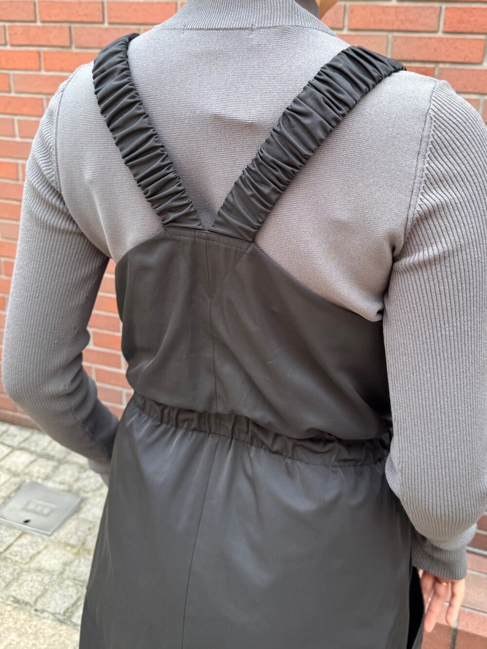 グレー系のニット/セーター、ブラック系のワンピースを着用したレディースの秋コーディネートの6枚目の写真