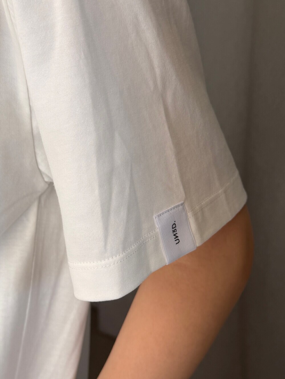 シルバー系のショルダーバッグ、ホワイト系のTシャツ/カットソー、ブラック系のスカートを着用したレディースの夏コーディネートの5枚目の写真