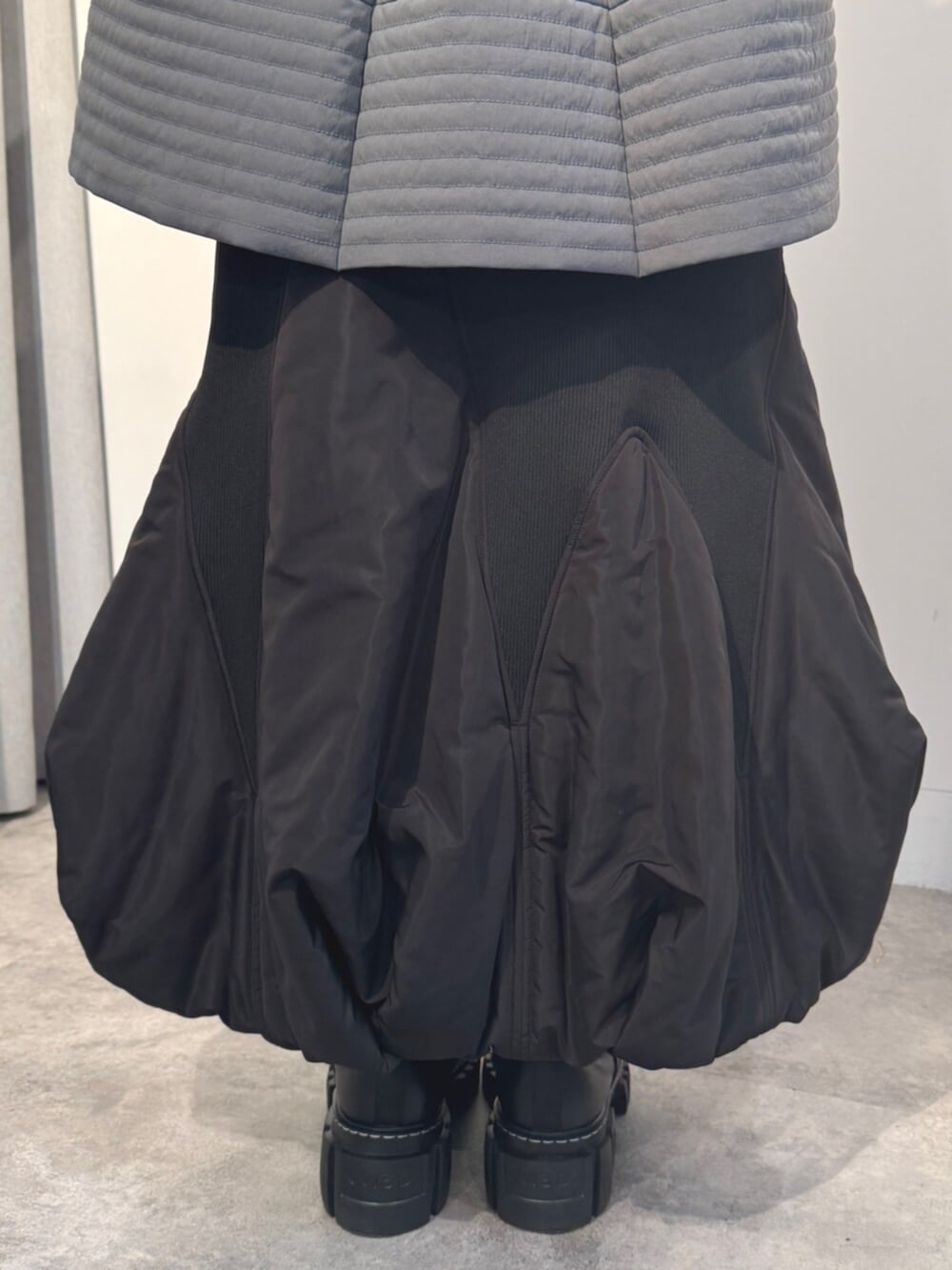 ブラック系のニット/セーター、ブラック系のスカート、グレー系のシャツ/ブラウスを着用したレディースの秋コーディネートの7枚目の写真