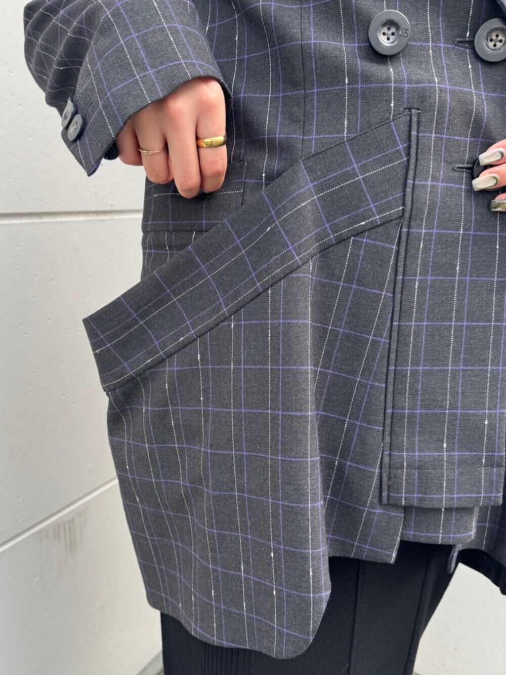 ブラック系のブーツ、グレー系のテーラードジャケット、ブラック系のワンピースを着用したレディースの秋コーディネートの6枚目の写真