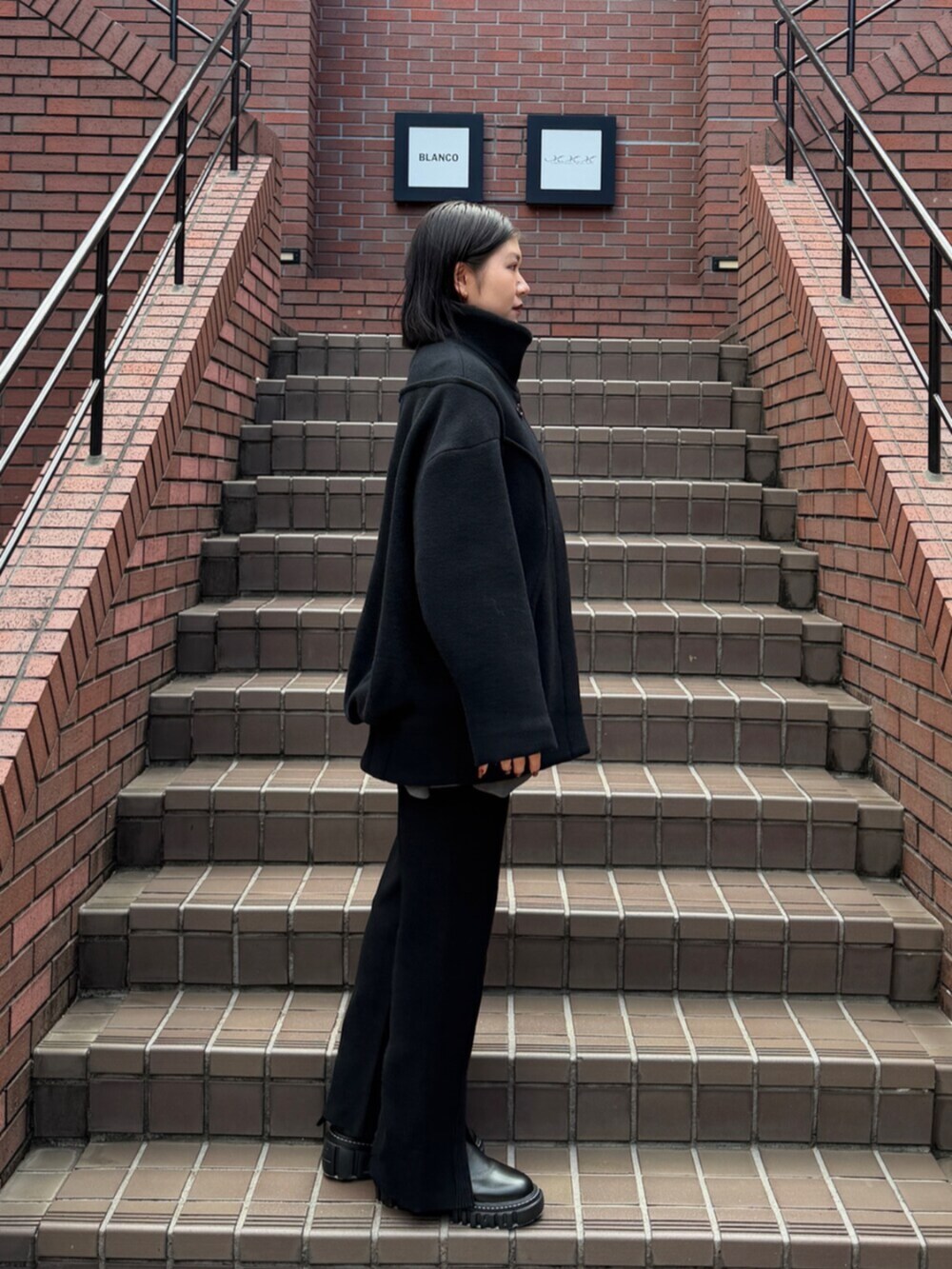 ブラック系のブーツ、ブラック系のその他アウターを着用したレディースの秋コーディネートの3枚目の写真