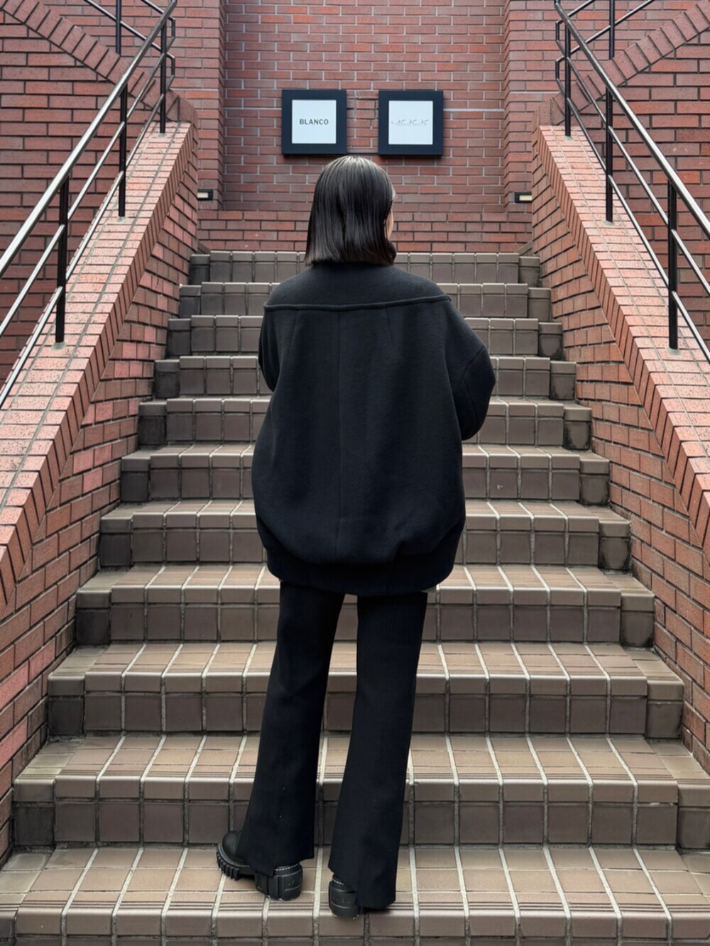 ブラック系のブーツ、ブラック系のその他アウターを着用したレディースの秋コーディネートの2枚目の写真