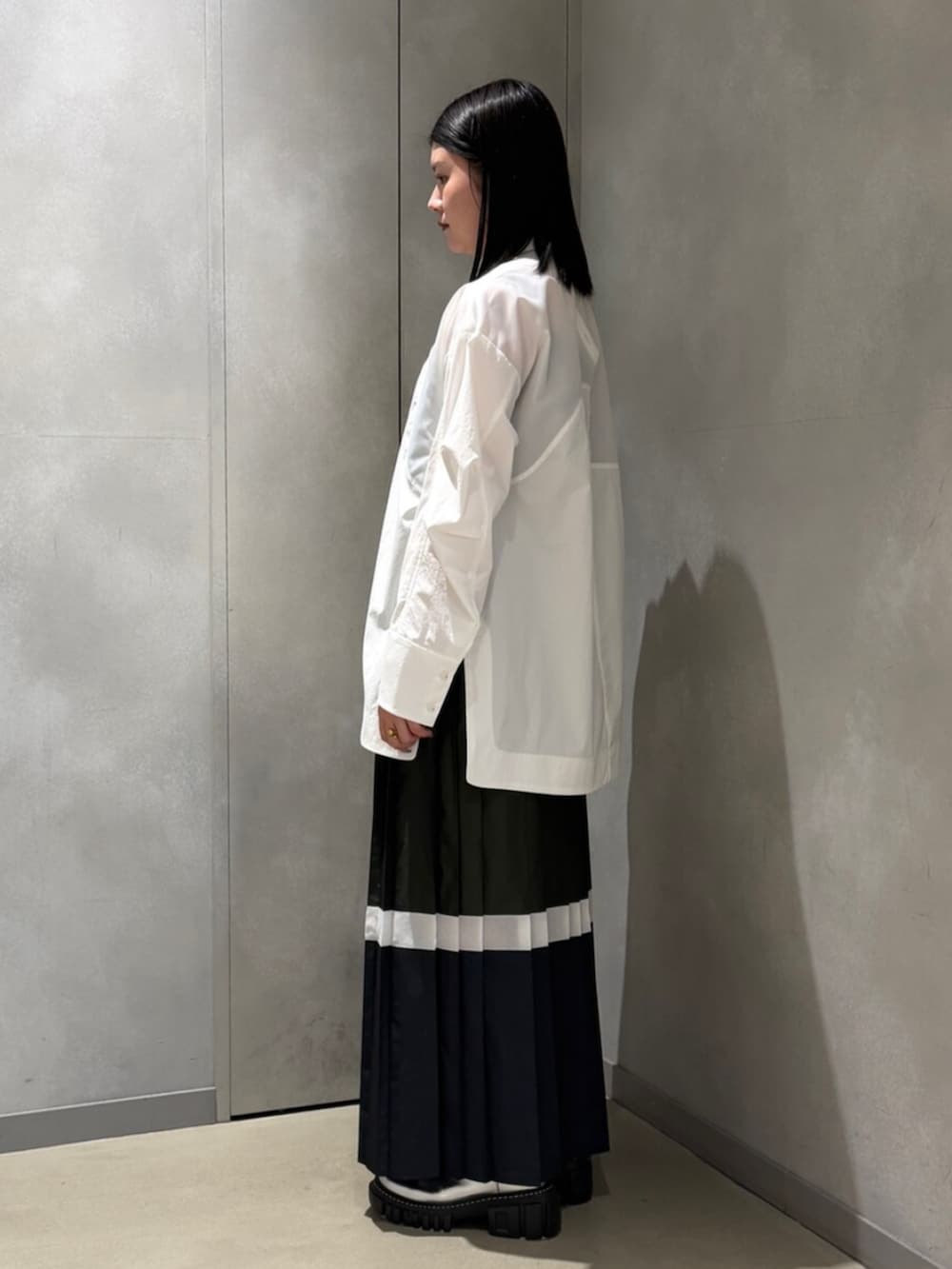 ホワイト系のシャツ/ブラウス、グリーン系のスカート、シルバー系のブーツを着用したレディースの春コーディネートの2枚目の写真