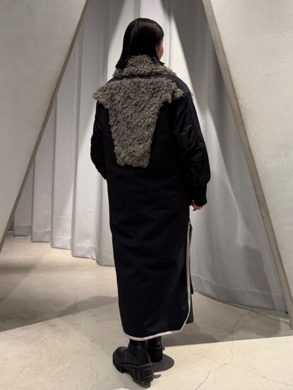 ブラック系のブーツ、ブラック系のその他アウター、ブラック系のその他パンツを着用したレディースの秋コーディネートの2枚目の写真