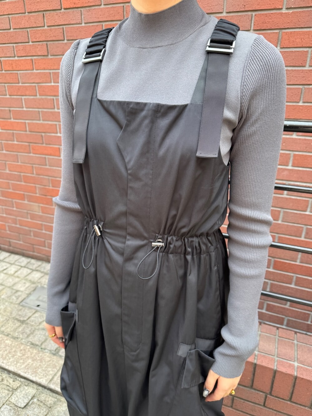 グレー系のニット/セーター、ブラック系のワンピースを着用したレディースの秋コーディネートの5枚目の写真