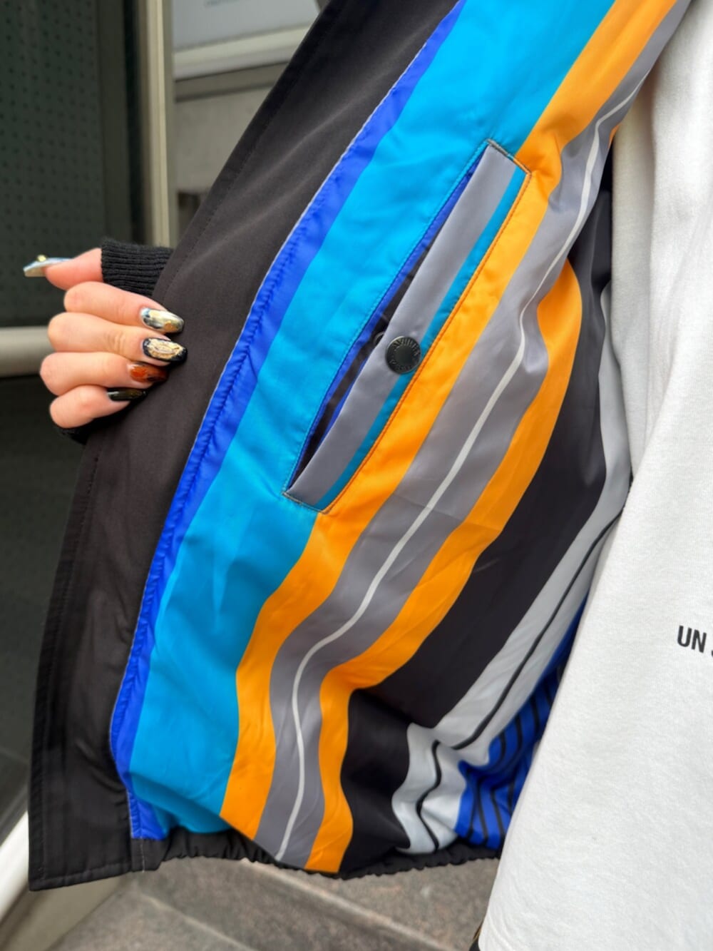 シルバー系のブーツ、ブラック系のブルゾン、ホワイト系のTシャツ/カットソーを着用したレディースの秋コーディネートの5枚目の写真