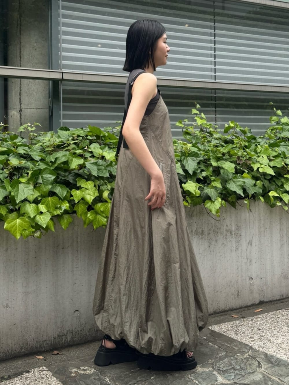 ブラック系のサンダル、ベージュ系のワンピースを着用したレディースの夏コーディネートの3枚目の写真