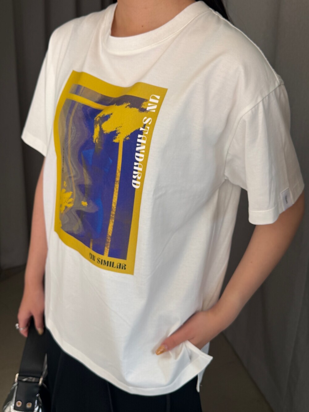シルバー系のショルダーバッグ、ホワイト系のTシャツ/カットソー、ブラック系のスカートを着用したレディースの夏コーディネートの4枚目の写真
