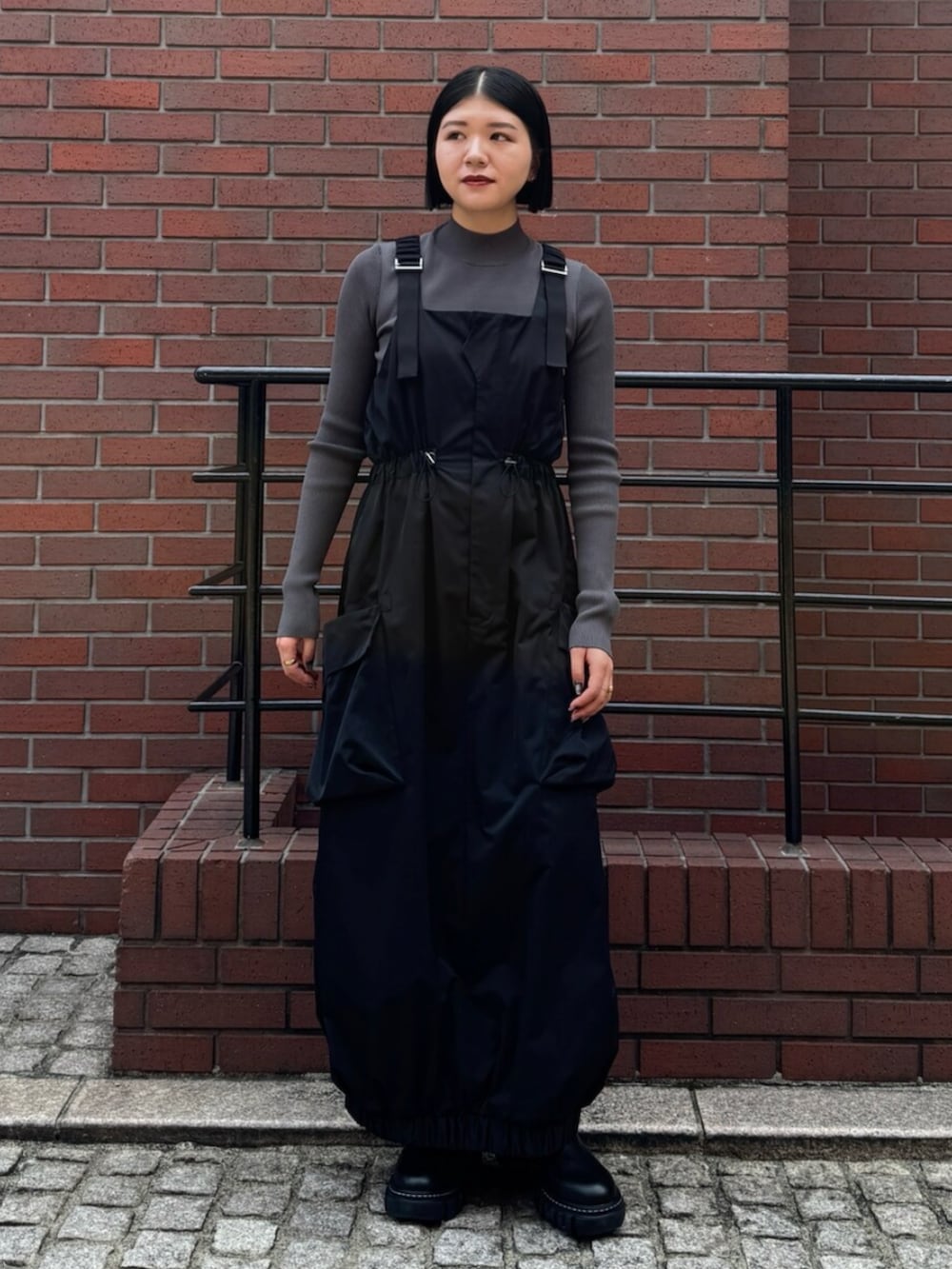 グレー系のニット/セーター、ブラック系のワンピースを着用したレディースの秋コーディネートの3枚目の写真