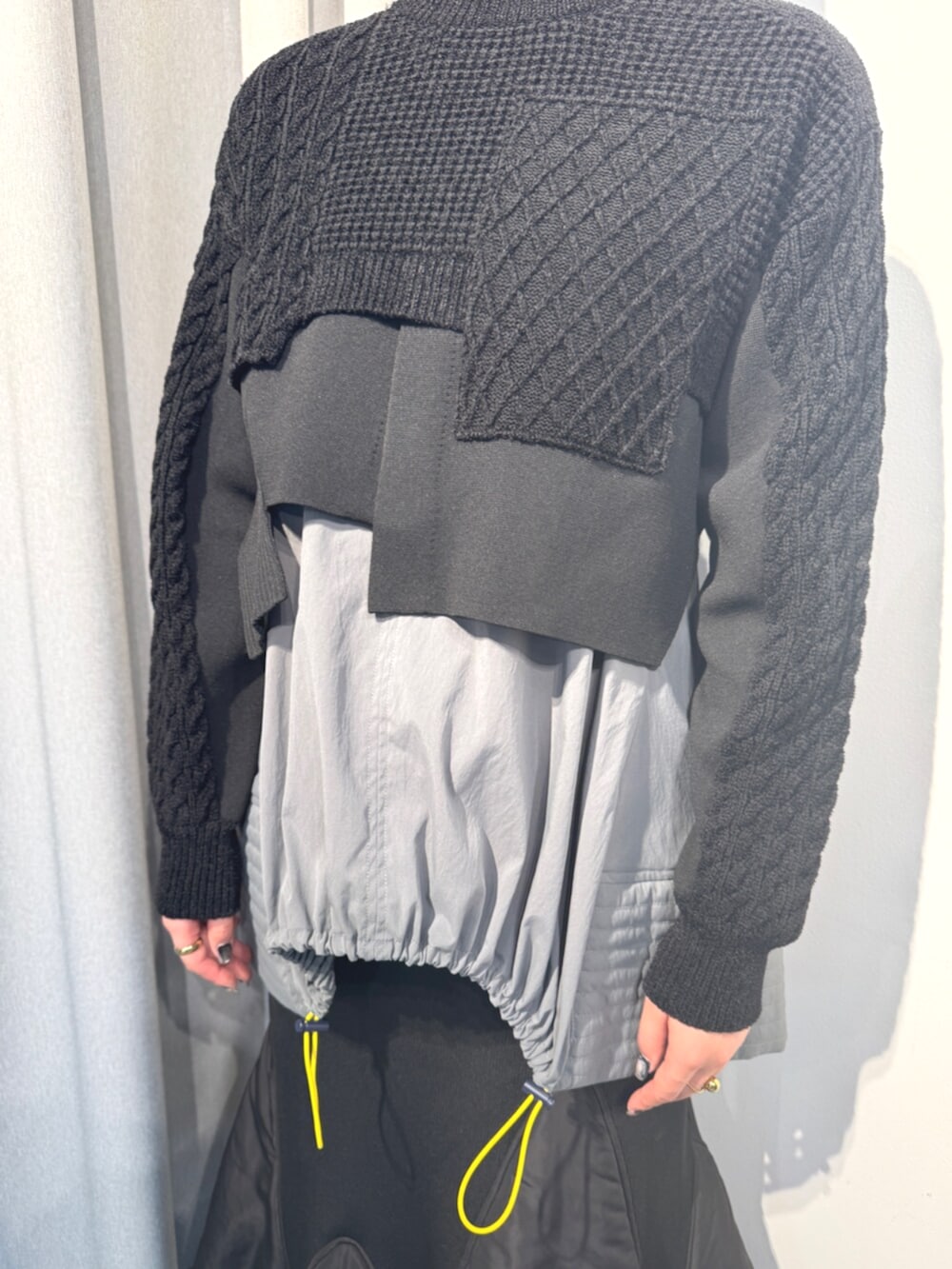 ブラック系のニット/セーター、ブラック系のスカート、グレー系のシャツ/ブラウスを着用したレディースの秋コーディネートの4枚目の写真