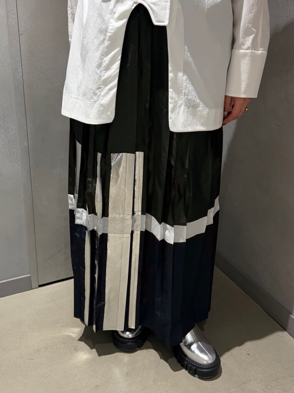 ホワイト系のシャツ/ブラウス、グリーン系のスカート、シルバー系のブーツを着用したレディースの春コーディネートの5枚目の写真