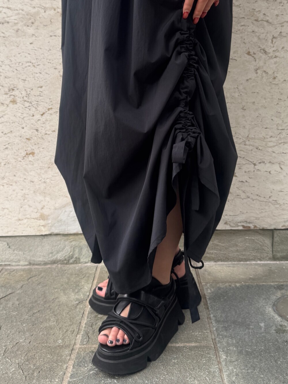 ブラック系のサンダル、ブラック系のワンピース、ブルー系のトートバッグを着用したレディースの夏コーディネートの5枚目の写真