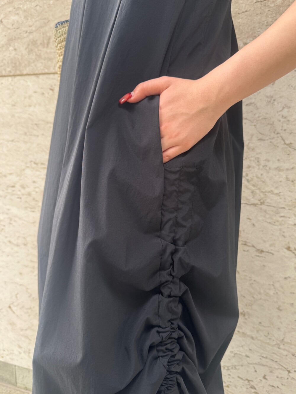 ブラック系のサンダル、ブラック系のワンピース、ブルー系のトートバッグを着用したレディースの夏コーディネートの6枚目の写真