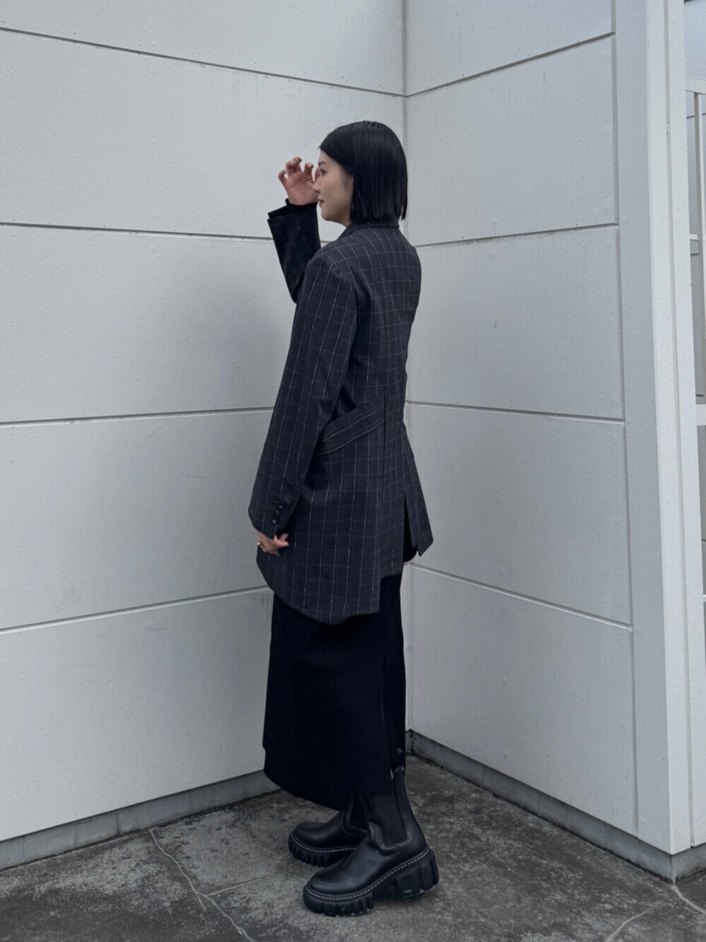 ブラック系のブーツ、グレー系のテーラードジャケット、ブラック系のワンピースを着用したレディースの秋コーディネートの2枚目の写真