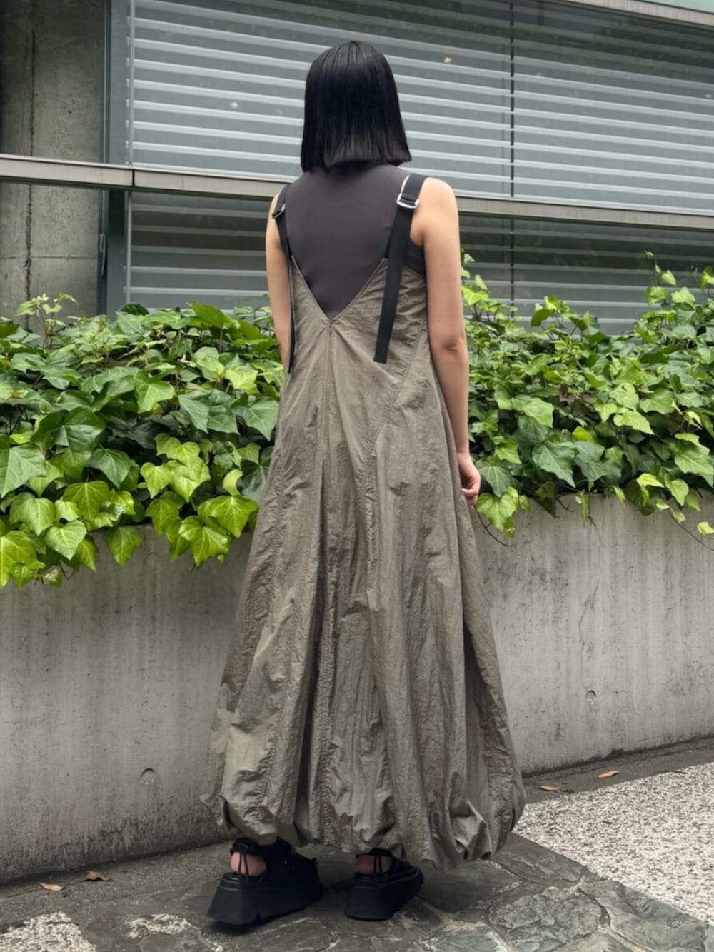 ブラック系のサンダル、ベージュ系のワンピースを着用したレディースの夏コーディネートの2枚目の写真