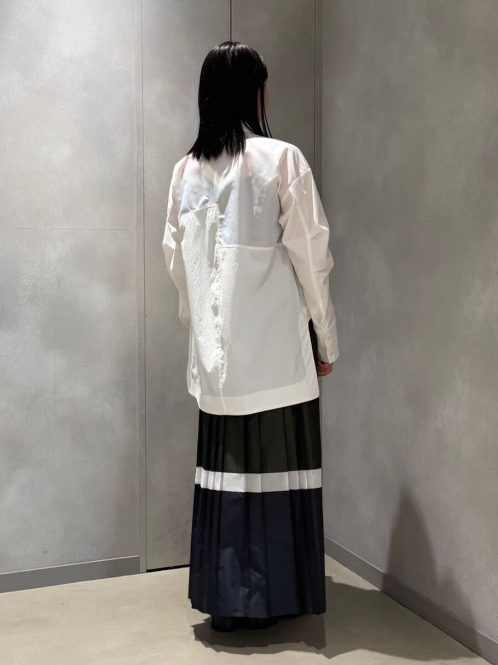 ホワイト系のシャツ/ブラウス、グリーン系のスカート、シルバー系のブーツを着用したレディースの春コーディネートの3枚目の写真