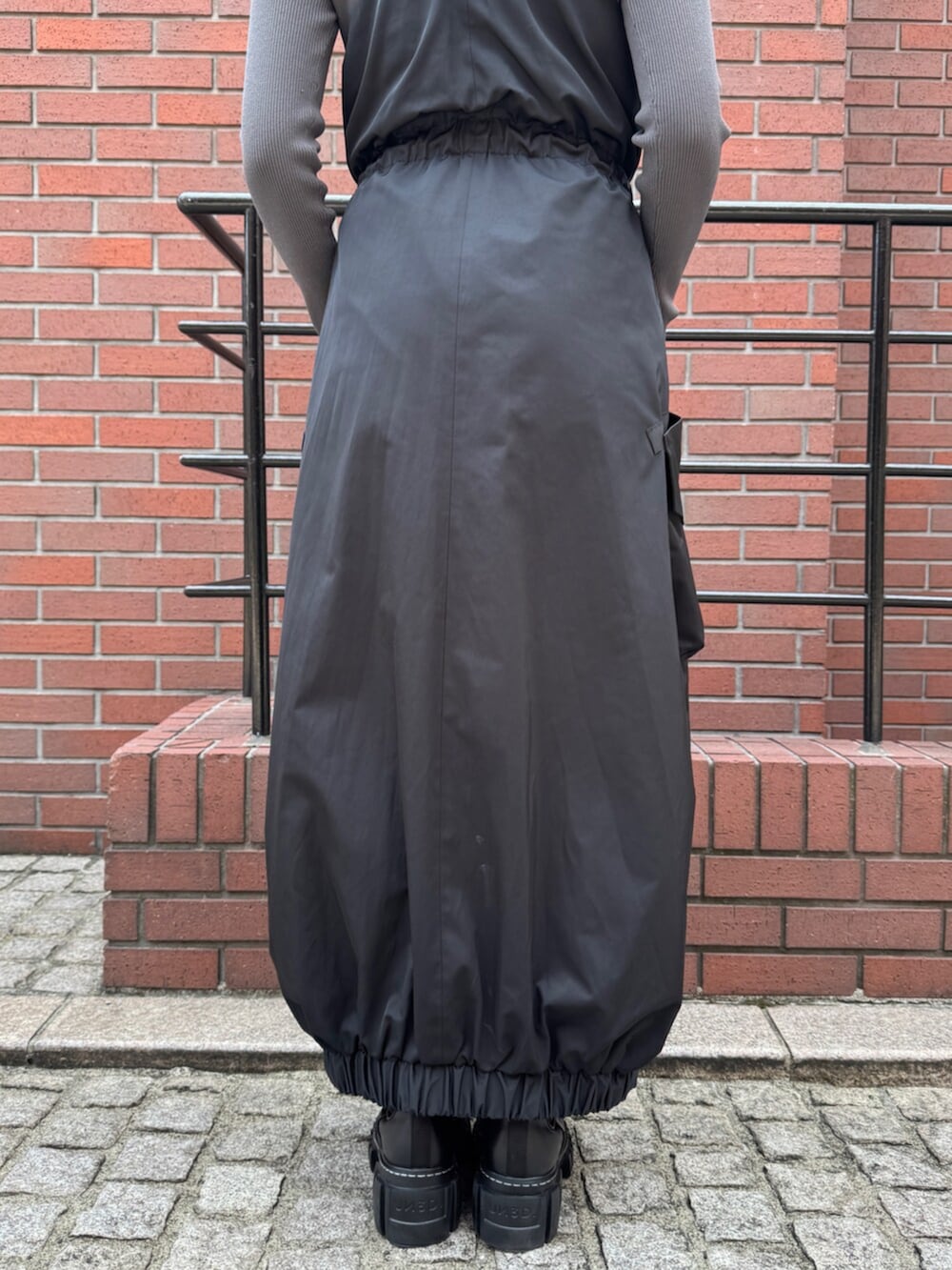 グレー系のニット/セーター、ブラック系のワンピースを着用したレディースの秋コーディネートの7枚目の写真