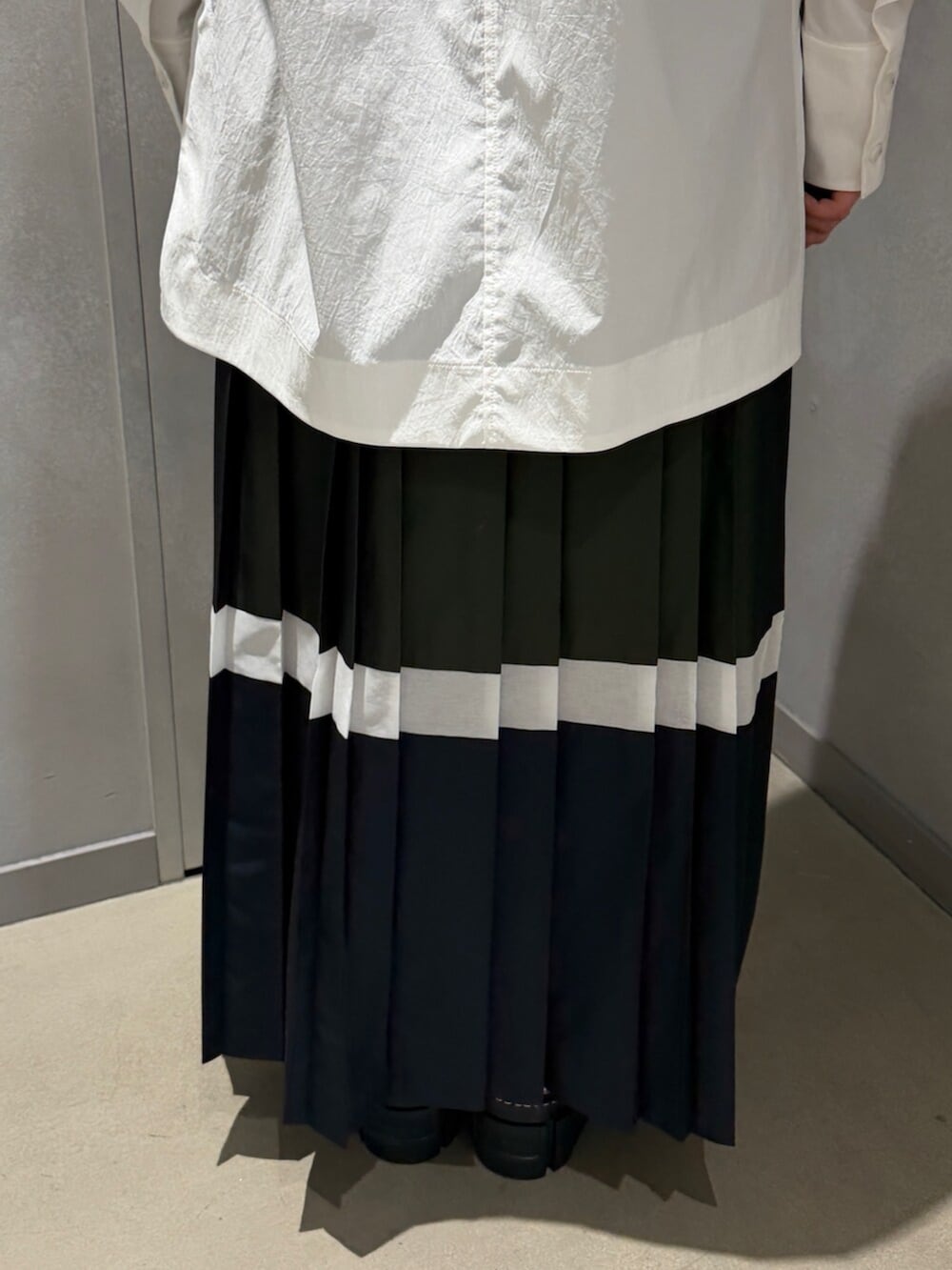 ホワイト系のシャツ/ブラウス、グリーン系のスカート、シルバー系のブーツを着用したレディースの春コーディネートの6枚目の写真