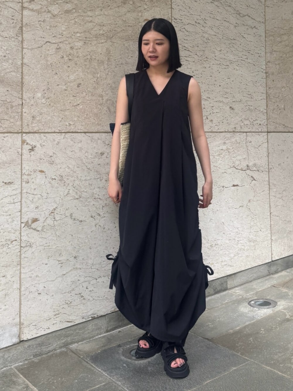 ブラック系のサンダル、ブラック系のワンピース、ブルー系のトートバッグを着用したレディースの夏コーディネートの2枚目の写真